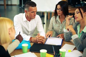 people having meeting around table in office