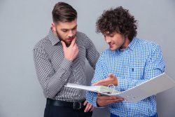  two people reading documents in folder about donors