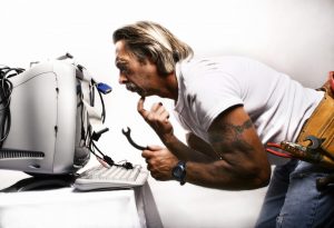 man fixing a computer who has no idea what he is doing
