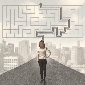 Business woman looking at road with maze and solution