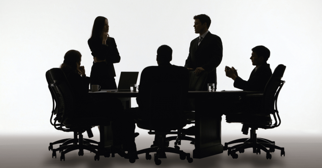 black white image of stressed group meeting