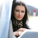 Woman leaning out of car, watching you.