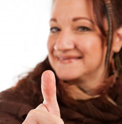 woman-smiling-and-holding-her-thumb-up-in-approval