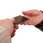 Hand passing a credit card